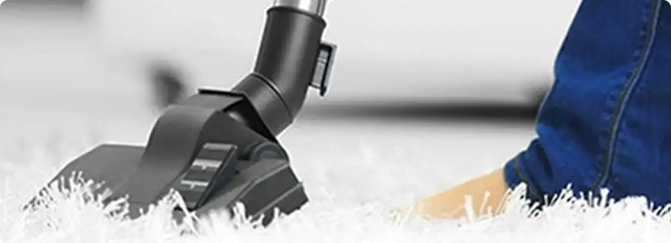 Close-up of a professional vacuuming a white carpet in Munroe Falls.